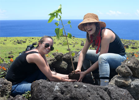 Happy women planting tree, reforesting Easter Island.