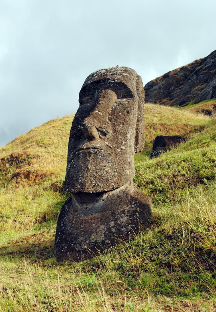 Single moai statue during sunrise at volcano Rano Raraku