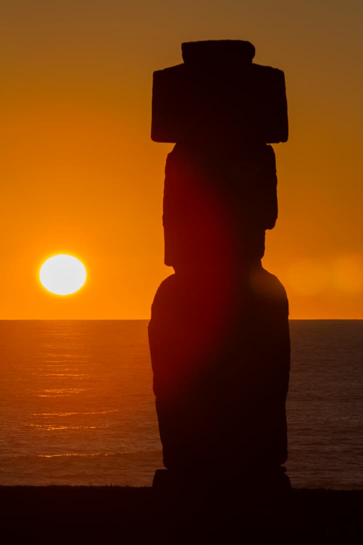 Close-up of sun setting behind moai statue Ahu Ko Te Riku at Rapa Nui (Easter Island)