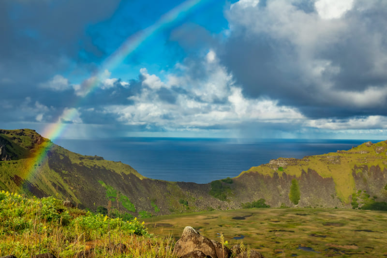 Rano Kau volcano after the rain during a trip to Rapa Nui, with a rainbow stretching over the crater.