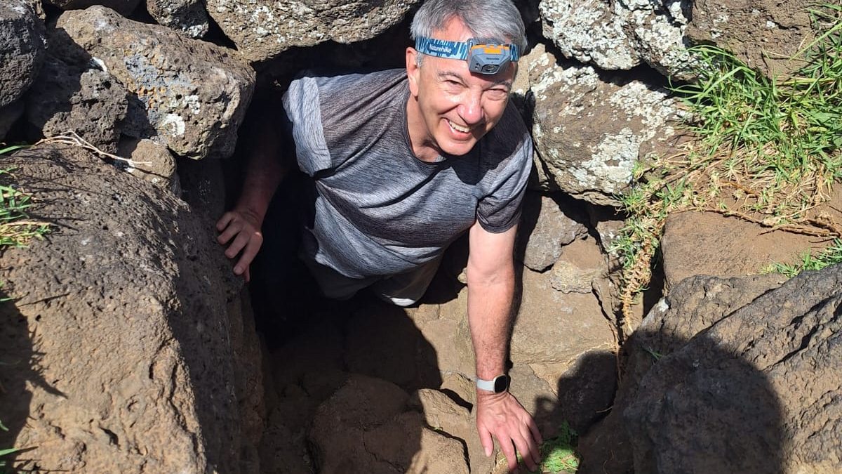 Emerging from the narrow volcanic tunnels of Ana Kakenga after a successful underground adventure.