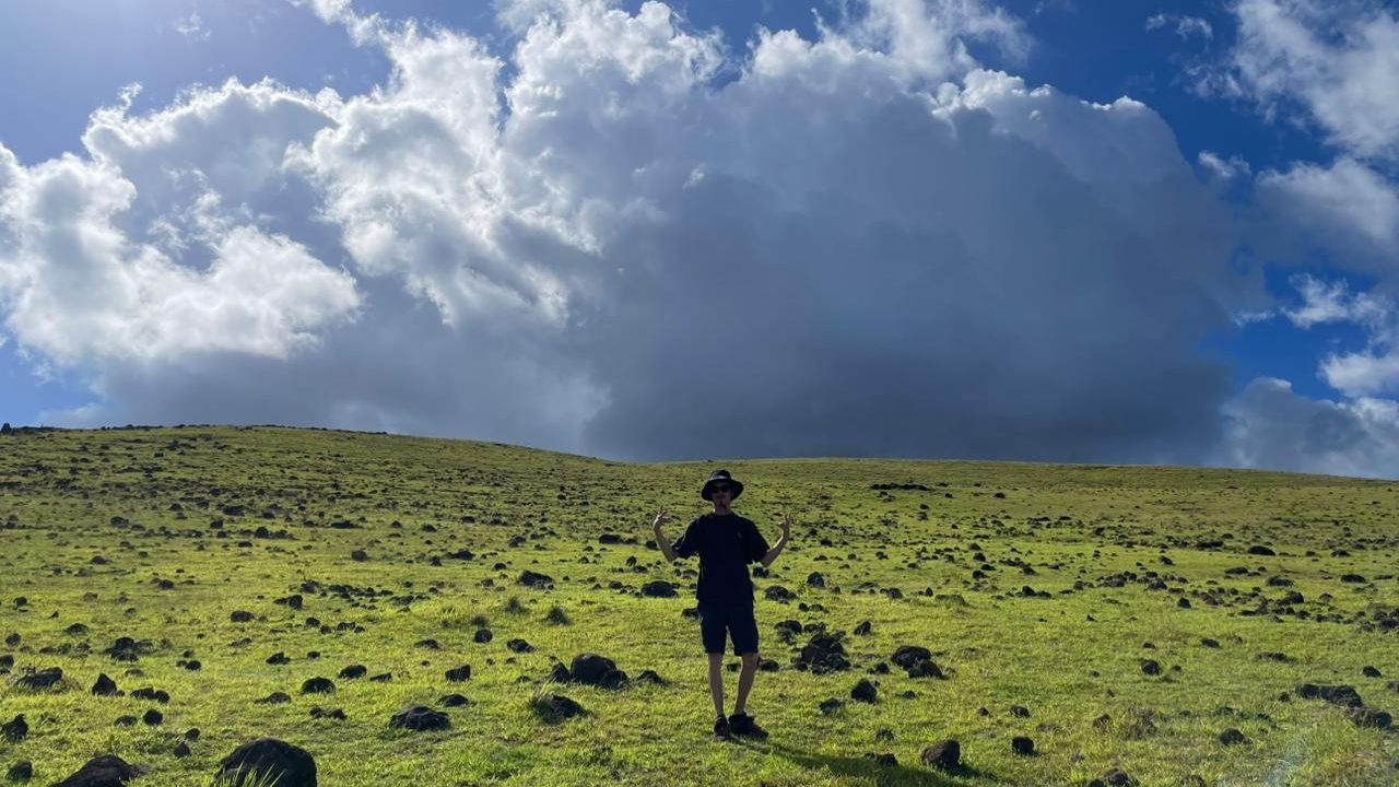 Wide volcanic landscape in the interior of Rapa Nui beneath an ever-changing sky.