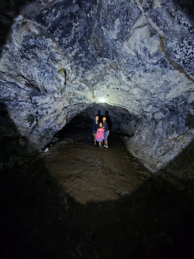 Three generations exploring the impressive lava tunnels of Ana Kakenga with the safety equipment required to experience the cave comfortably and securely.
