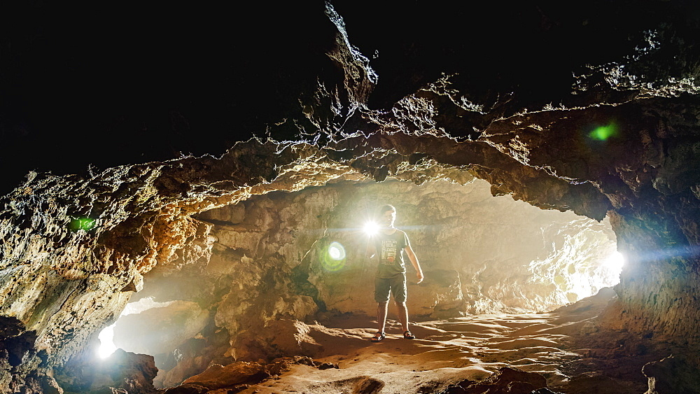Exploring the interior of Ana Kakenga with proper lighting, an essential part of safely discovering this ancient lava tube.