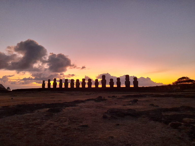 Sunrise behind the fifteen moai of Ahu Tongariki during a tour in Easter Island.
