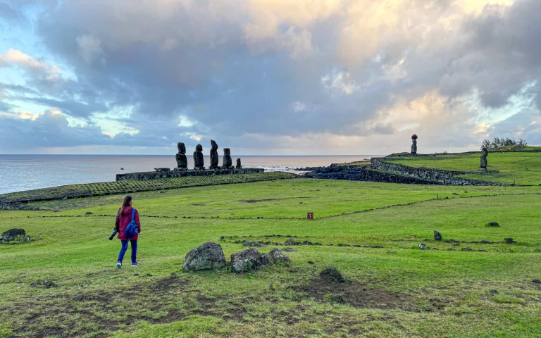 Traveler walking through Tahai at sunset on Easter Island.