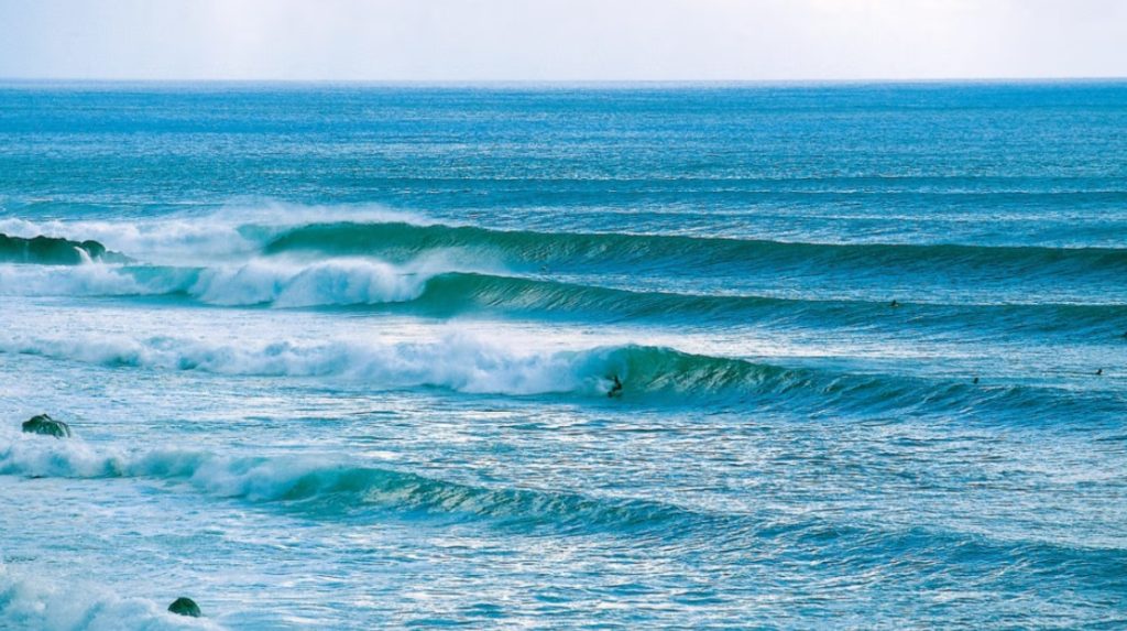 Ordered lines of waves breaking on the coast, showcasing ideal surfing conditions on Rapa Nui (Easter Island).