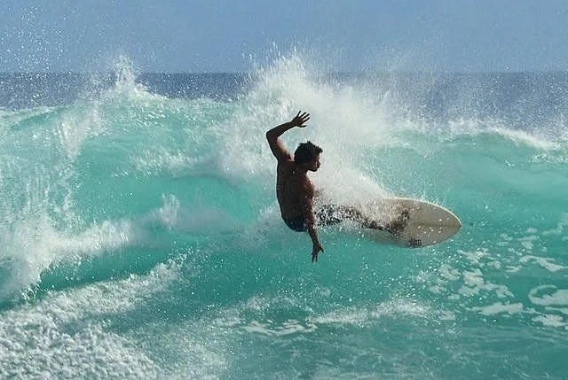 A surfer performing a radical maneuver on a wave, capturing the adrenaline of surfing in Rapa Nui and the quality of the waves on Easter Island.