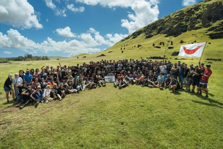 Production crew and cast of the movie Wild Horse Nine Rapa Nui posing together with the Rapa Nui flag and the Rano Raraku quarry in the background.
