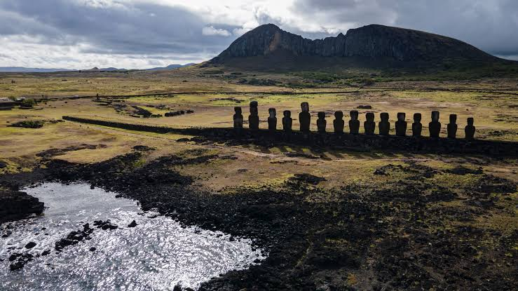 Drone capture from behind Ahu Tongariki with the Rano Raraku volcano on the horizon in Wild Horse Nine Rapa Nui.