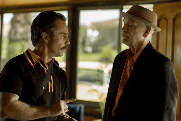 Sam Rockwell and John Malkovich conversing in an indoor retro setting in Wild Horse Nine