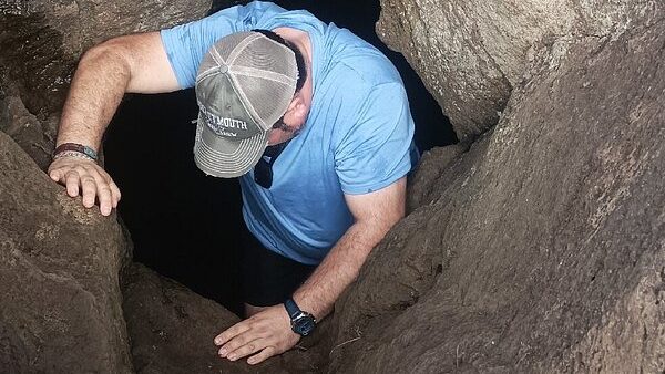 Demostración de la entrada a una "Ana Kionga" o cueva de defensa durante el tour guiado.