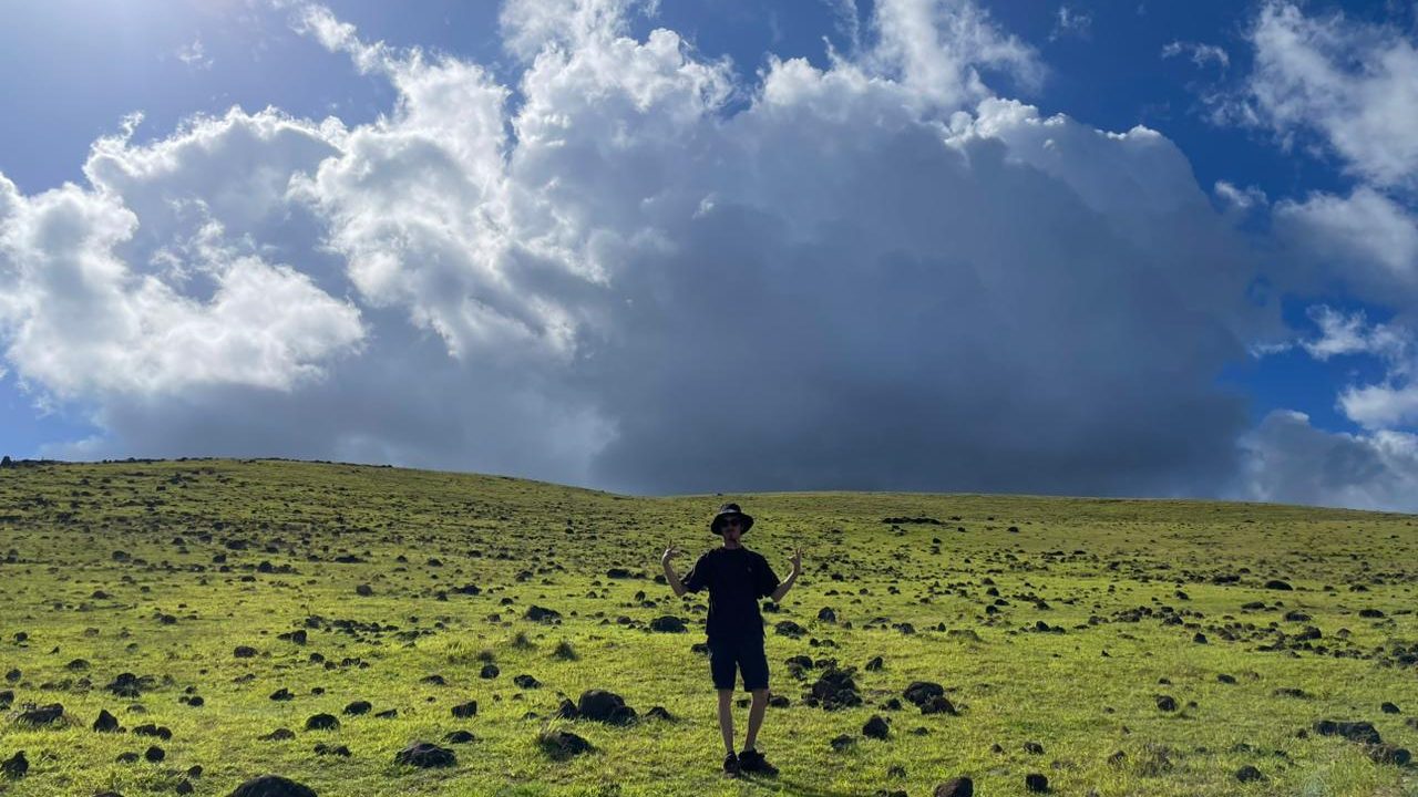 Amplio paisaje volcánico del interior de Rapa Nui bajo un cielo cambiante.