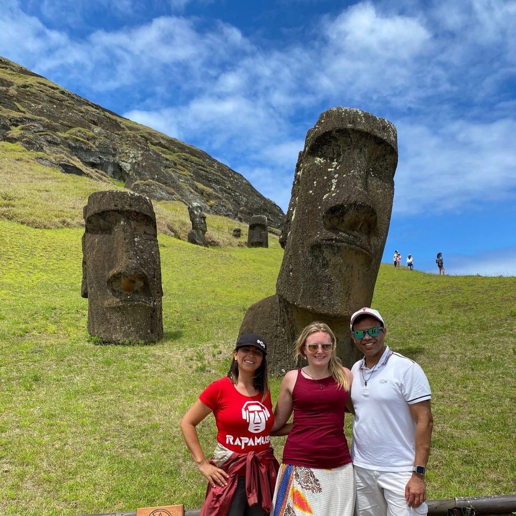 Tourists posing in front of the ancient Moai statues on the volcanic slopes of Rano Raraku during a private excursion.