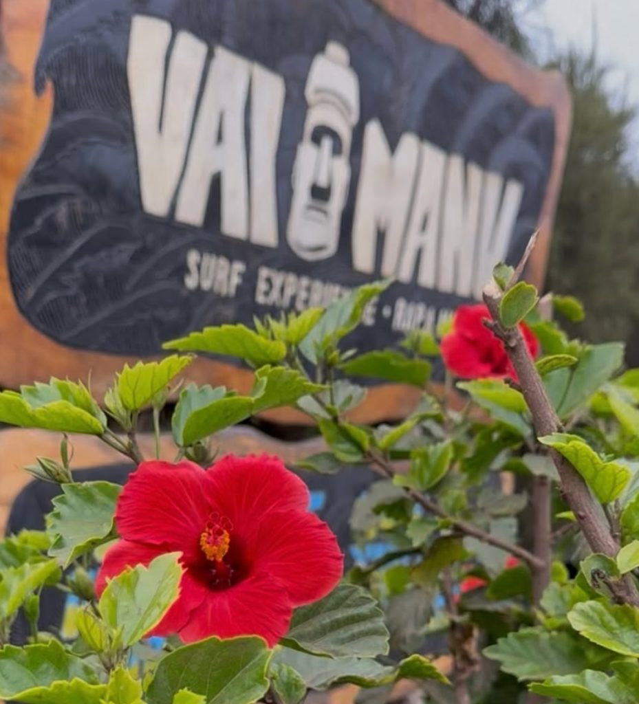 Letrero de madera tallada de la escuela de surf "Vai Manu" en Rapa Nui, destacando las opciones locales para el Surf en isla de pascua.