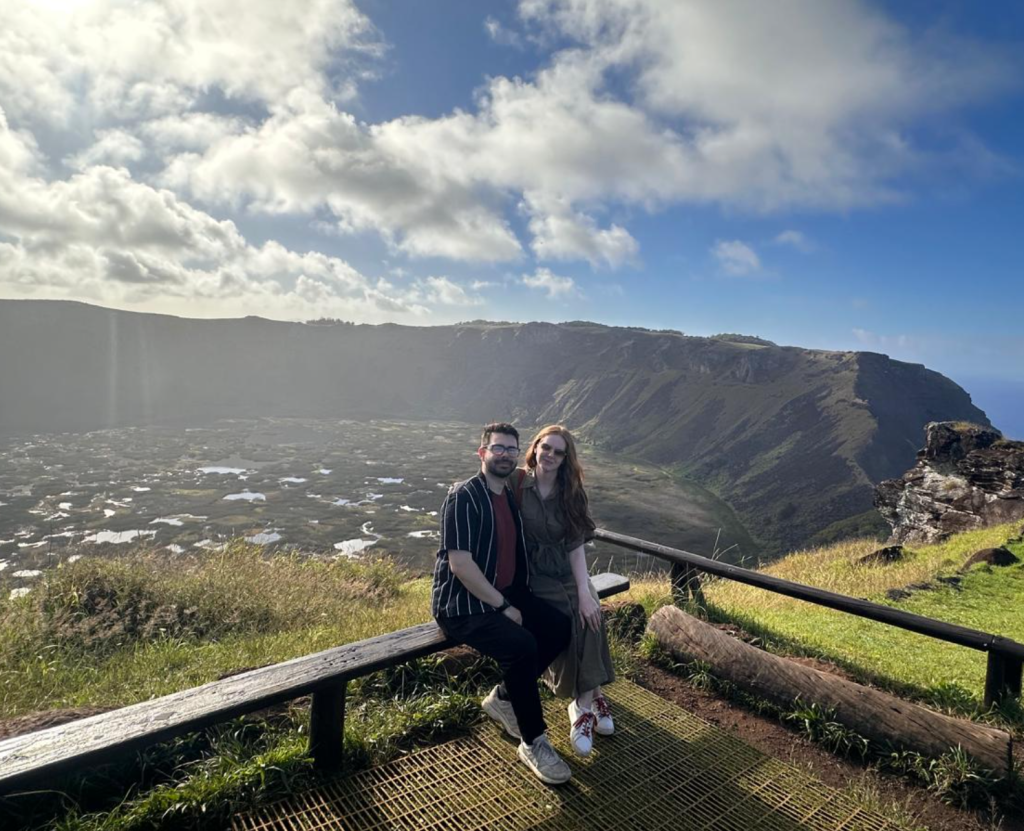 A photo of a tourist couple at Rano Kau, filled with excitement at the sight of the volcano's landscape and the vast Pacific Ocean in the background. They took this photo while on a private tour of Rapa Nui.