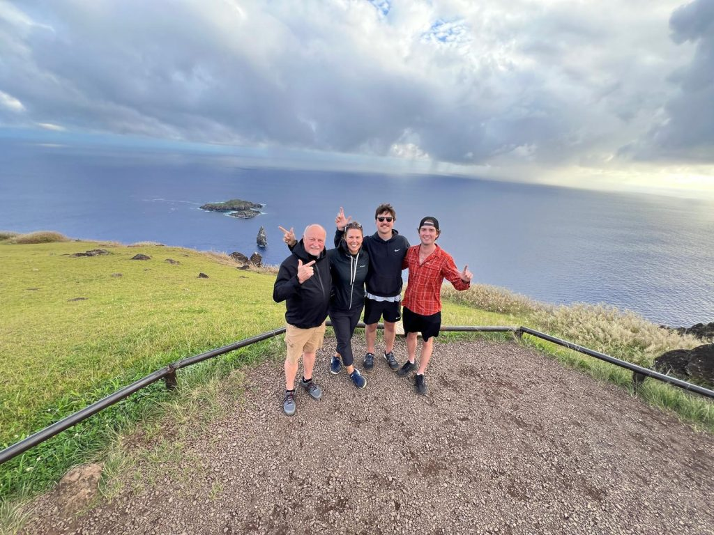 Tourists visiting Orongo while respecting the marked boundaries, with the offshore islets and Pacific Ocean in the background.