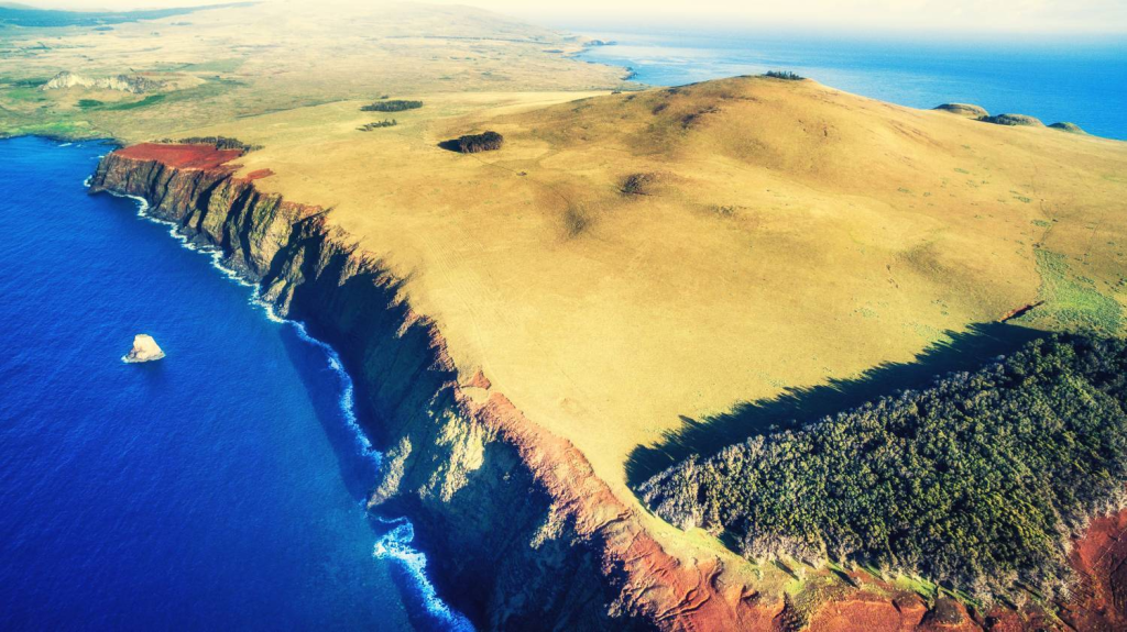 Aerial view from Poike showing vegetation and an eroded volcanic cliff along the coast of Rapa Nui.