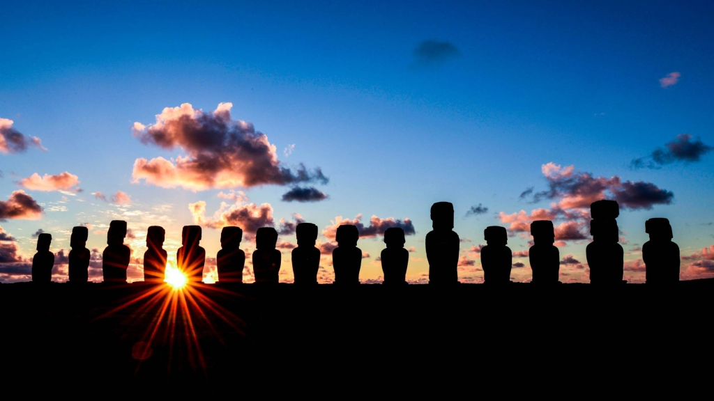 Sol brillando entre dos moai de Ahu Tongariki durante un amanecer de verano en Rapa Nui