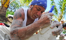 Man carving stone moai at Tapati Rapa Nui festival, Easter Island